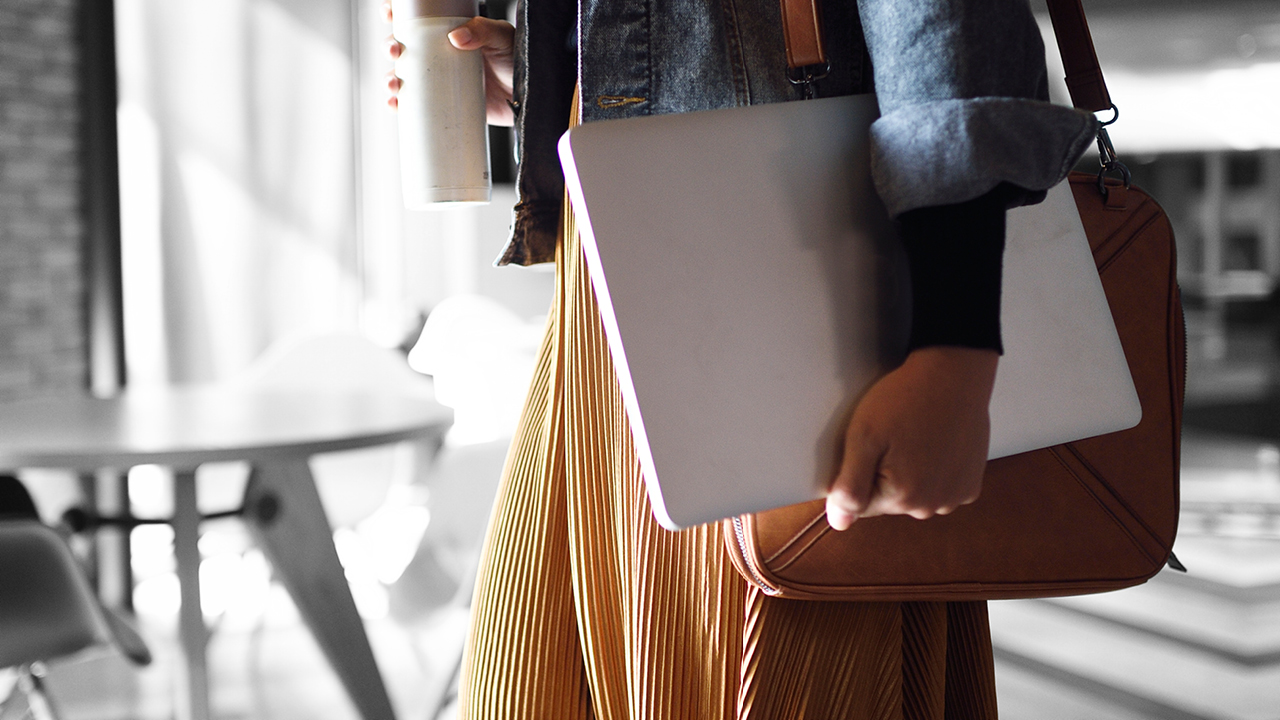 A woman carring her laptop and a bottle of water on a street; image used for HSBC Australia Credit cards.