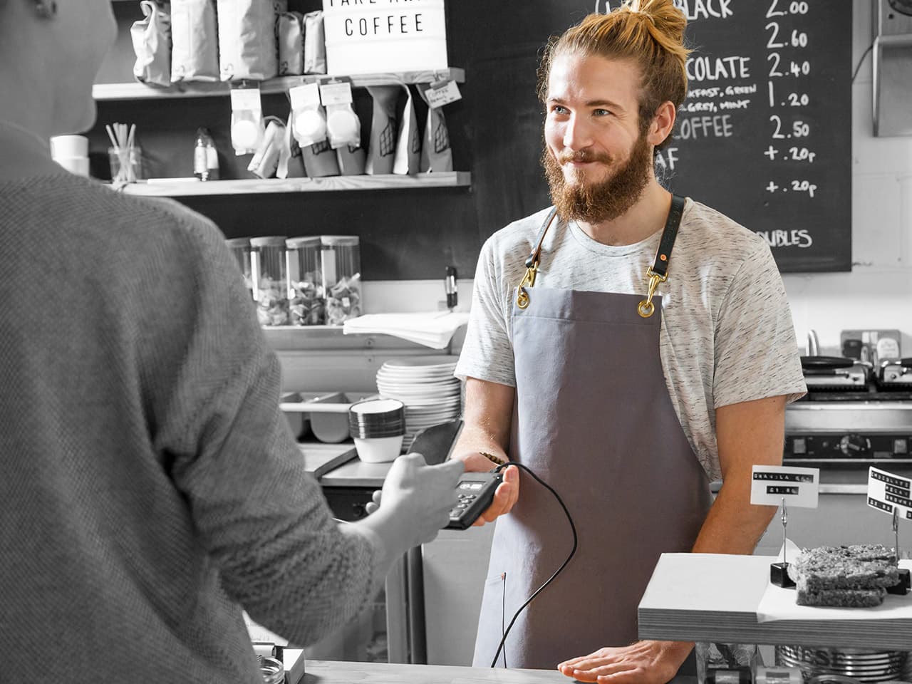 A man is paying his purchase at a coffee shop